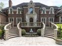 The home's entrance features dual staircases leading to an arched doorway and water feature at 5420 Deer Forest Trl, Raleigh, NC 27614