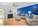 Bright living room featuring a fireplace, hardwood floors, and stylish furniture against a bold blue wall at 6001 Winterpointe Ln # 102, Raleigh, NC 27606
