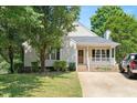 Inviting home with a brick-lined porch, mature trees, and a well-manicured lawn at 604 Sinewell Dr, Wake Forest, NC 27587