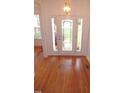 View of the foyer featuring hardwood floors with inlaid starburst design and leaded glass front door at 6673 Nc 96 W Hwy, Youngsville, NC 27596