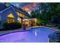 Beautiful backyard with pool, screened porch, dining area, and professional landscaping at sunset at 754 Olde Thompson Creek Ct Rd, Apex, NC 27523