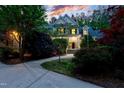 Inviting two-story home with a well-manicured front yard and charming evening illumination at 754 Olde Thompson Creek Ct Rd, Apex, NC 27523