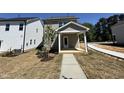 Rear view of a charming two-story home with a covered porch and landscaped backyard at 773 Portland Rose Dr, Knightdale, NC 27545