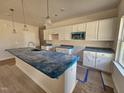 Bright and spacious kitchen featuring white cabinets, granite countertops, and a large island at 79 Mildred Dr, Broadway, NC 27505