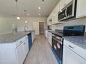 Bright kitchen boasts stainless steel appliances, granite countertops, and a walk-in pantry at 79 Mildred Dr, Broadway, NC 27505
