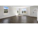 Inviting living room with wood-look flooring has an abundance of natural light from the multiple windows at 832 Old Tarboro Rd, Wendell, NC 27591