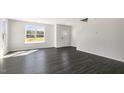 Bright living room boasts large windows, allowing natural light to illuminate the stylish, wood-look flooring at 832 Old Tarboro Rd, Wendell, NC 27591