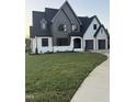 Charming two-story modern home with gray and white painted brick, a manicured lawn, and an inviting curved driveway at 833 Dunleigh Dr, Burlington, NC 27215