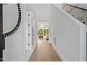 Bright hallway with hardwood floors and view of the living room's chandelier at 833 Dunleigh Dr, Burlington, NC 27215