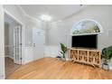 Cozy living room featuring an arched window, hardwood floors, and stylish decor at 8437 Whisper Ridge Pl, Raleigh, NC 27613