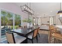 Bright dining room with a modern chandelier, large windows, and access to the backyard at 1002 Shovelhead Dr # 58, Durham, NC 27703
