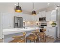 Modern kitchen featuring white cabinets, stainless steel appliances, and a quartz countertop island at 1002 Shovelhead Dr # 58, Durham, NC 27703