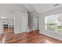 Inviting living area showcasing sleek hardwood floors, a bright window, and a staircase to the upper level at 104 Harvolly Dr, Holly Springs, NC 27540