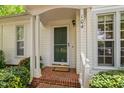 Charming front porch featuring a green door, brick steps, and detailed trim at 104 Planetree Ln, Cary, NC 27511