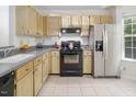 Bright kitchen with modern stainless steel refrigerator and black appliances at 104 Sir Richard Ln, Chapel Hill, NC 27517