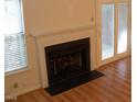 Corner of the living room featuring a fireplace, a window with natural light, and sliding glass doors to outside at 104 Sir Richard Ln, Chapel Hill, NC 27517