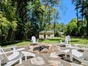 Inviting backyard fire pit area with white Adirondack chairs, perfect for outdoor entertaining at 107 Forest Rd, Oxford, NC 27565