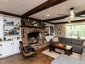 Cozy living room with exposed ceiling beams, brick fireplace, and built-in bookcases at 107 Forest Rd, Oxford, NC 27565