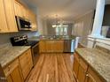 Spacious kitchen featuring stainless steel appliances, granite counters, and wood floors at 113 Conner Dr # 103, Chapel Hill, NC 27514