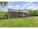 Beautiful brick home featuring classic shutters, a welcoming porch, and landscaped front yard at 1303 Cherry Dr, Burlington, NC 27215