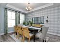 Elegant dining room with a chandelier, wainscoting, and a view to outside at 137 Cultivator Ct, Angier, NC 27501