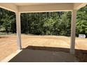 Inviting covered patio space with views of the tranquil wooded backyard at 169 Pecan Valley Way, Four Oaks, NC 27524