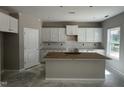 Bright kitchen features white cabinets, a center island, and tile backsplash at 169 Pecan Valley Way, Four Oaks, NC 27524