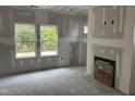 Spacious living room with a fireplace and large windows ready for your customization at 169 Pecan Valley Way, Four Oaks, NC 27524