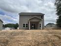 Two-story home featuring gray siding, large windows, and a covered porch ready for your personal touch at 169 Pecan Valley Way, Four Oaks, NC 27524