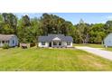Inviting single-story home with a lush green lawn and picturesque landscaping at 1914 Jack Rd, Clayton, NC 27520