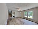 Bright living room with modern flooring, neutral paint, and staircase with a fireplace at 202 November St, Garner, NC 27529