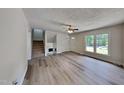 Bright living room with modern flooring, neutral paint, and staircase with a fireplace at 202 November St, Garner, NC 27529
