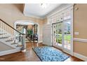 Bright foyer featuring hardwood floors, a staircase, and an inviting front door at 205 Buncombe St, Raleigh, NC 27609