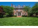 Beautifully maintained front yard with a brick facade home, lush green lawn, and mature trees at 205 Buncombe St, Raleigh, NC 27609