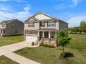 Beautiful two-story home with a stone-accented facade, manicured lawn, and welcoming front porch at 2415 Ivy Knoll Dr, Mebane, NC 27302