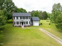 Traditional two-story home with gray siding, black shutters, and a large, grassy yard at 3004 Red Cir, Willow Springs, NC 27592