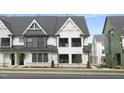 New construction two story townhouse with a modern white facade and detailed architectural features and landscaping at 3018 White Rail Dr, Fuquay Varina, NC 27526