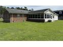 Exterior view of the home's backyard featuring a well-maintained lawn and sunroom at 405 Taylor Dr, Rocky Mount, NC 27803
