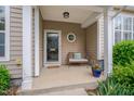 Charming covered front porch featuring a bench, potted plants, and stylish exterior lighting at 4306 Brynwood Ave, Durham, NC 27713