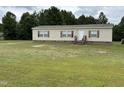 Single-story home with tan siding and red shutters on a large grassy lot with trees in the background at 4855 Mike Ln, Nashville, NC 27856