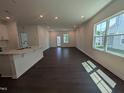 Bright living room with recessed lighting, dark wood floors, and large windows offering ample natural light at 521 Morning Light Dr, Angier, NC 27501
