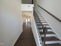 Elegant staircase with dark wood handrail and wrought iron spindles leading to open living space with wood floors at 521 Morning Light Dr, Angier, NC 27501