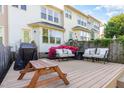 Relaxing backyard deck with cushioned seating, grill, and a wooden picnic table at 521 Village Loop Dr, Apex, NC 27502