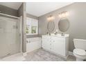 Neutral bathroom with a double vanity, soaking tub, and a glass-enclosed shower at 521 Village Loop Dr, Apex, NC 27502