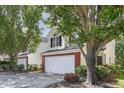 Two-story home boasts mature trees, complementing the white siding and brick accented garage at 5456 Grand Traverse Dr, Raleigh, NC 27604