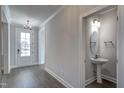 Elegant entryway features a decorative chandelier, light gray walls, and a stylish powder room with pedestal sink at 63 W Victoria Ridge Dr # 31, Selma, NC 27576