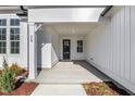 Inviting covered front porch with a stylish black front door and modern design elements at 63 W Victoria Ridge Dr # 31, Selma, NC 27576