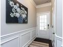 Inviting entryway with a rug, white wainscoting and a decorative floral artwork at 6341 Grace Lily Dr, Raleigh, NC 27607