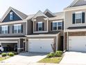 Two-story townhome featuring a spacious two-car garage and a well-maintained lawn at 6341 Grace Lily Dr, Raleigh, NC 27607