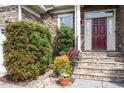 Inviting front porch features a stone walkway, manicured shrubs, and a red front door at 913 S South Bend Dr, Durham, NC 27713